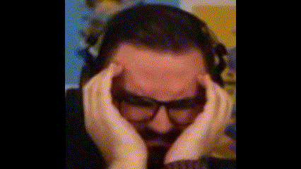 a man with glasses and headphones is holding his head with his hands .