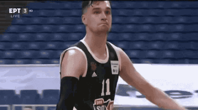a basketball player with the number 11 on his jersey is standing on the court .