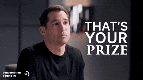 a man in a black shirt is sitting in front of a sign that says that 's your prize