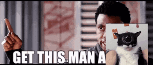 a man is pointing at a picture of a cat with the words get this man a below it