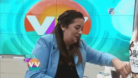 a woman is sitting in front of a tv screen that says vv