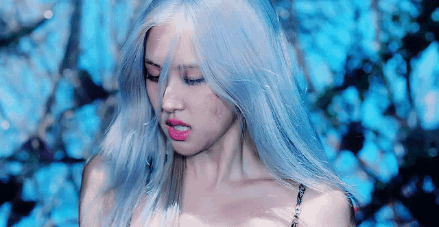 a close up of a woman with blue hair and pink lipstick