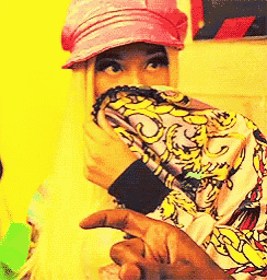 a woman wearing a pink hat is covering her face with her hands