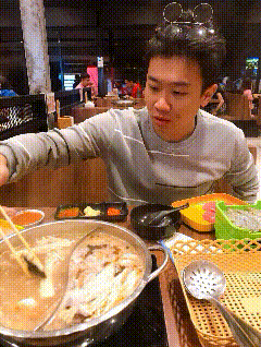 a man wearing mickey mouse ears is cooking food in a pot