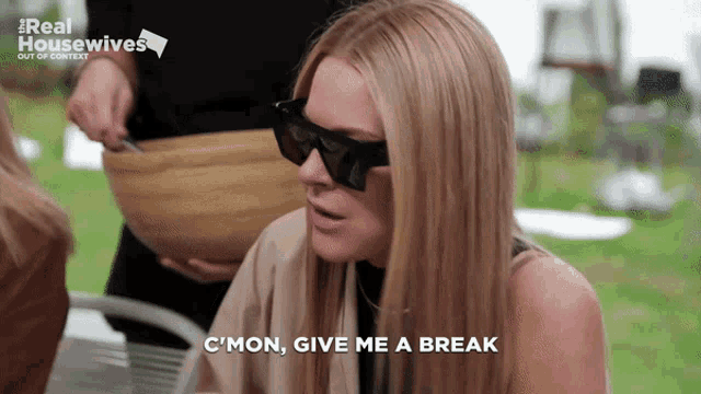 a woman wearing sunglasses says " c'mon give me a break " while sitting at a table