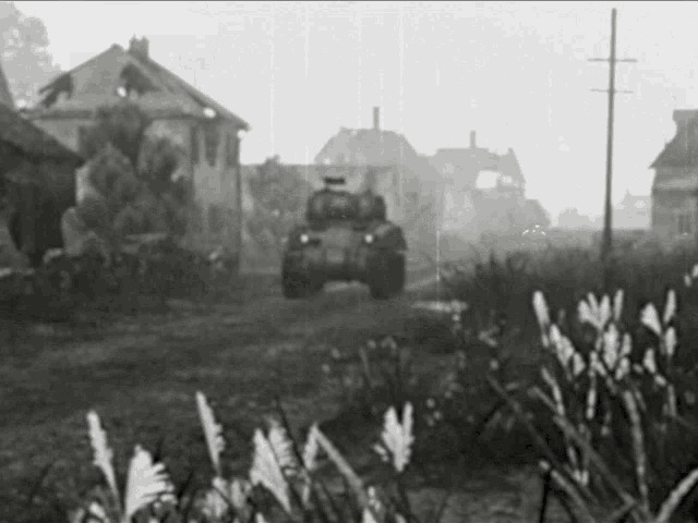 a black and white photo of a tank driving down a street