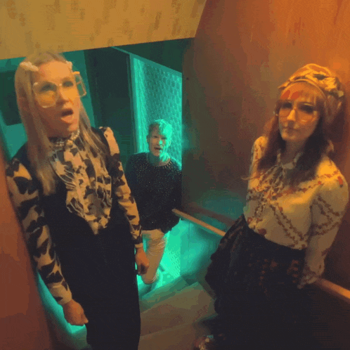 three people are standing on a set of stairs with one wearing glasses