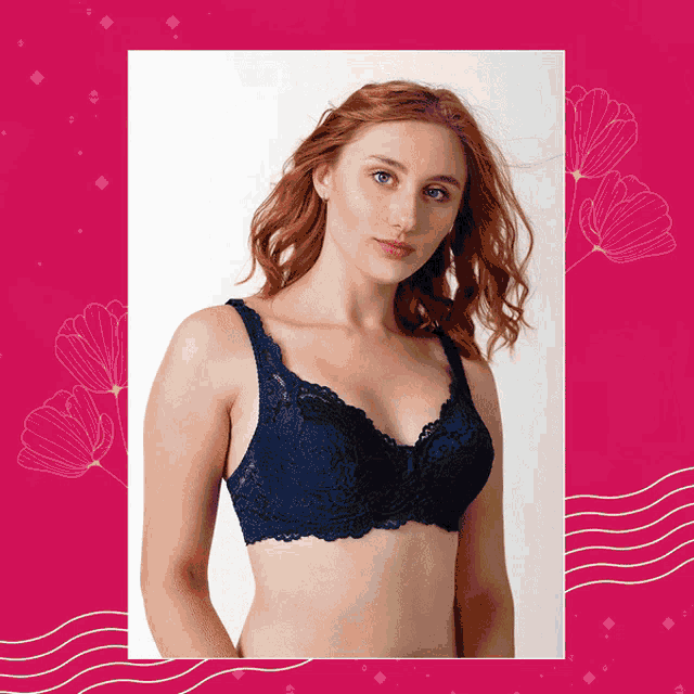 a woman in a blue lace bra is standing in front of a pink background