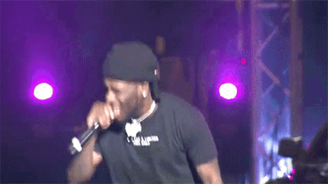 a man singing into a microphone with a necklace that says " i love you "