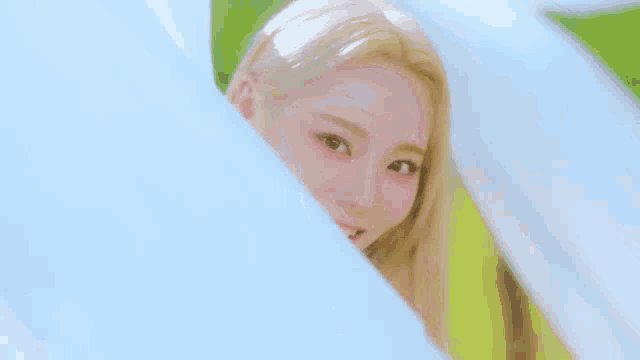 a close up of a woman 's face with long blonde hair and pink lips .