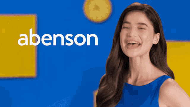 a woman in a blue dress is laughing in front of a blue and yellow background that says abenson