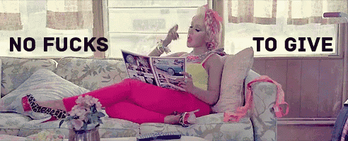 a woman is laying on a couch reading a magazine with the words " no fucks to give " above her