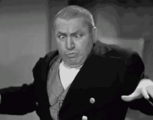 a black and white photo of a man in a suit making a funny face