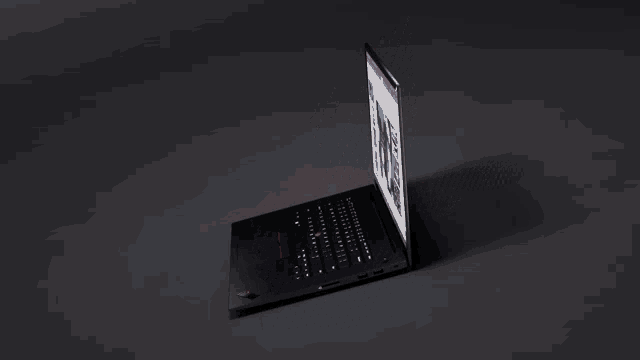 a black thinkpad x1 laptop with a red light on it