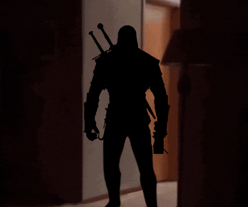 a silhouette of a man with a sword on his back standing in a dark hallway