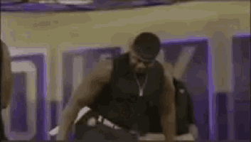 a man is doing push ups in a gym with a purple background .