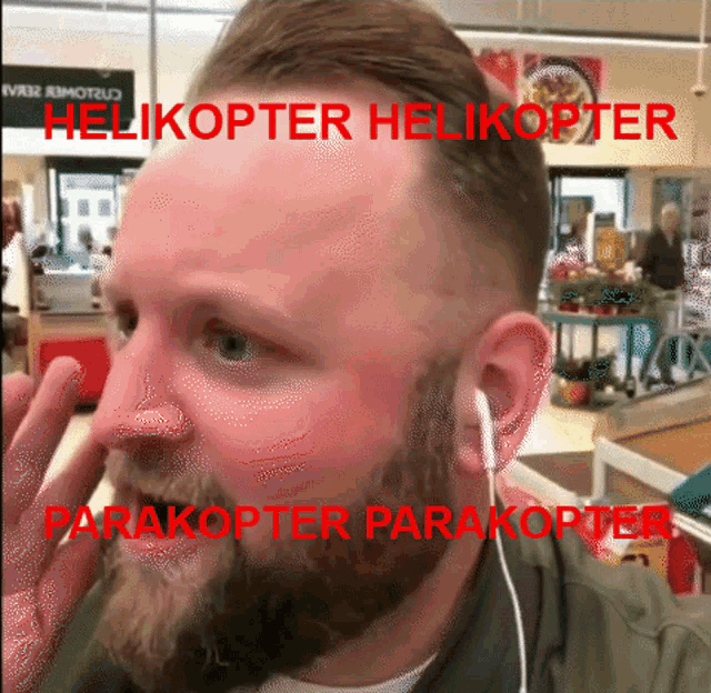 a man with a beard is wearing ear buds and the words helicopter helicopter parakoter parakoter are on his face