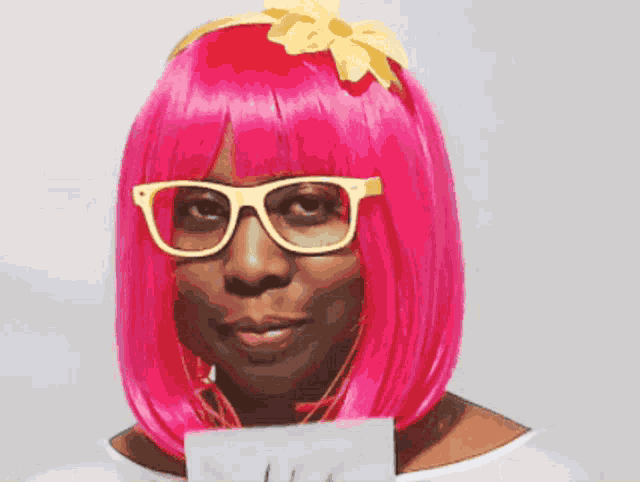 a woman with pink hair and glasses holding a sign that says yes