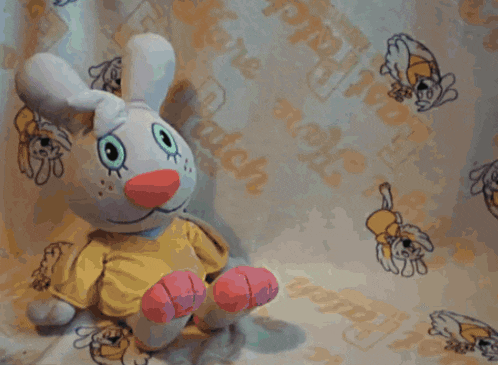a stuffed bunny is sitting in front of a curtain that says ' love rabbit ' on it