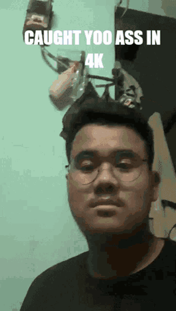 a man wearing glasses has the words caught yoo ass in 4k above him