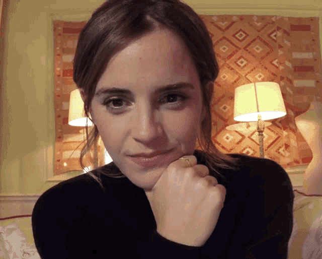 a woman wearing a black sweater and a ring on her finger