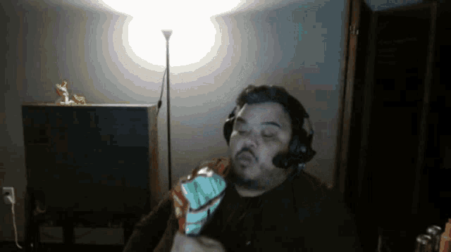 a man wearing headphones holds a bag of chips in his hand
