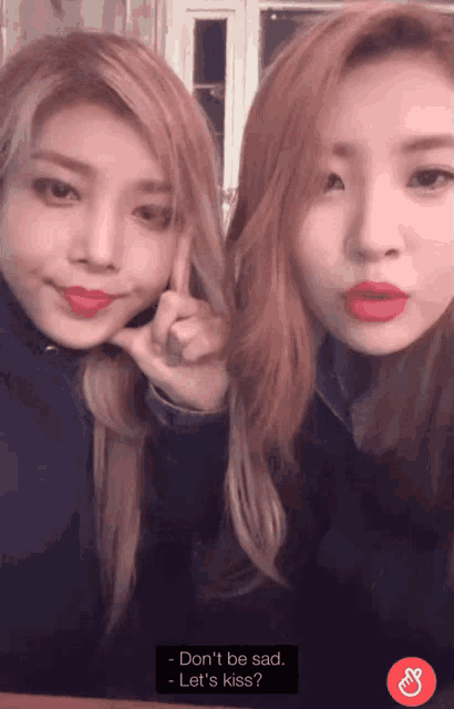 two girls are posing for a picture and one says " don 't be sad "