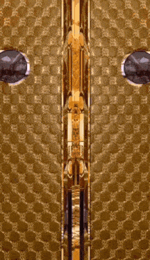 a gold door with a geometric pattern and a round window