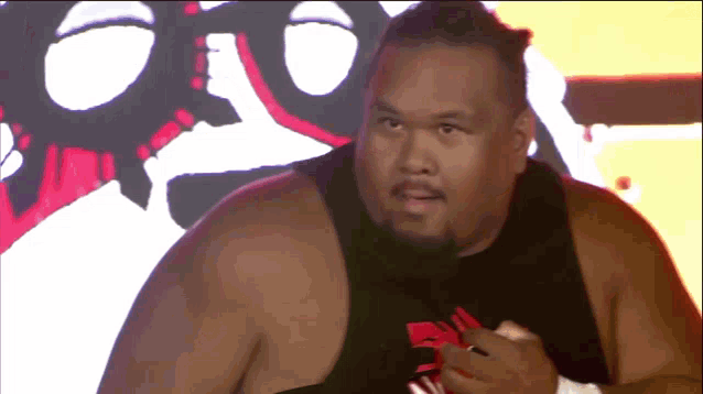 a man wearing a black tank top with a red letter r on it