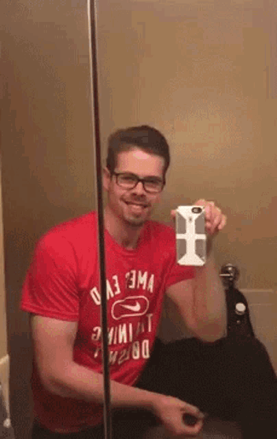 a man in a red shirt is taking a selfie