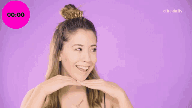 a woman is smiling in front of a purple background and a pink circle that says 00:00
