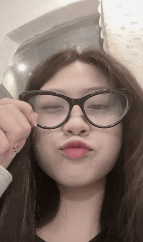 a woman wearing glasses has a tattoo on her thumb that says ' i love you '
