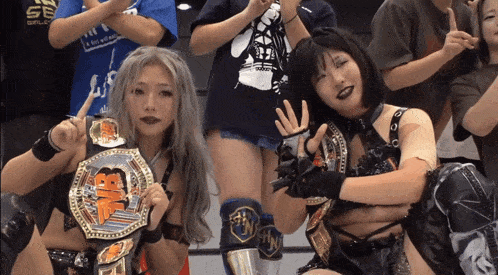 two female wrestlers posing for a picture with one wearing a belt that says ' ns ' on it