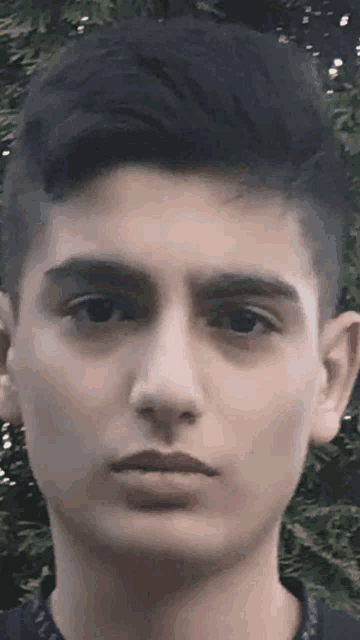 a close up of a young man 's face looking at the camera