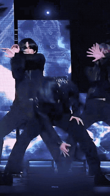 a man in a black suit is dancing in front of a screen that says opalita