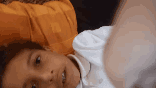 a young boy with braces on his teeth is laying on a bed