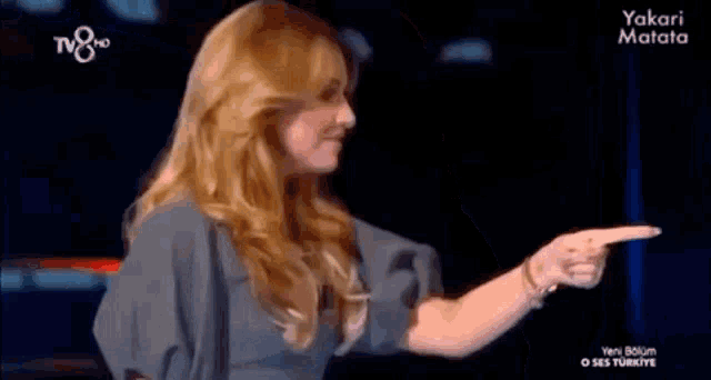 a woman is pointing her finger at something on a tv show