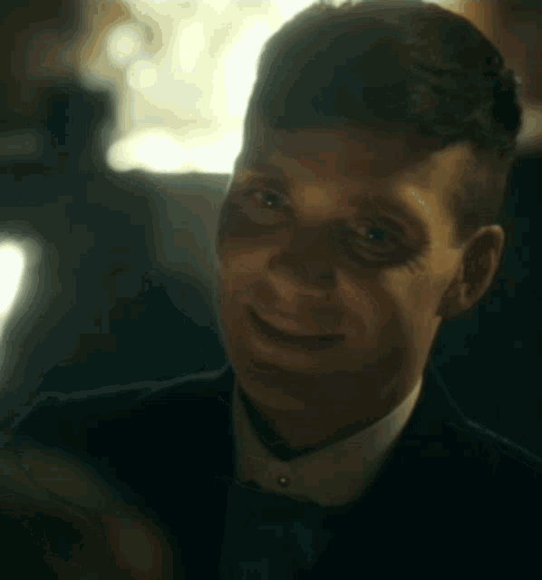 a man in a suit and tie is smiling and looking at the camera .