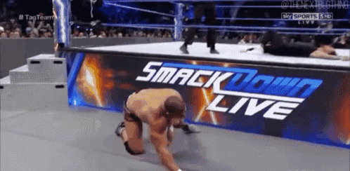 a man is kneeling down in front of a sign that says smackdown live .