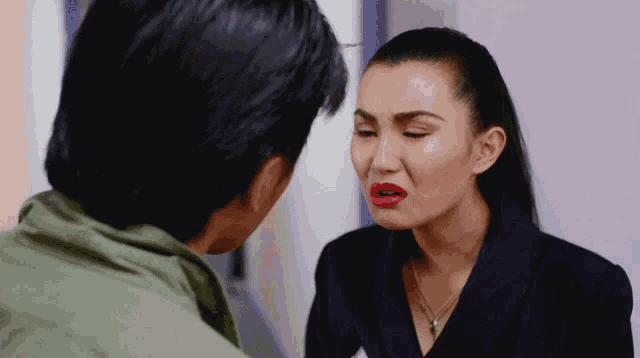 a man and a woman are looking at each other and the woman has red lips
