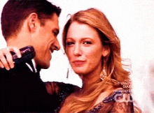 a man is holding a microphone while a woman looks at him
