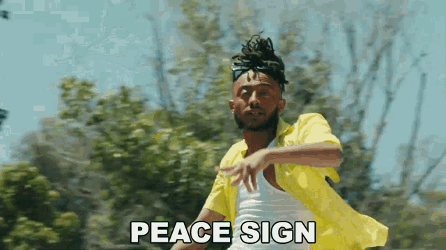 a man in a yellow shirt is dancing and the words peace sign are visible behind him