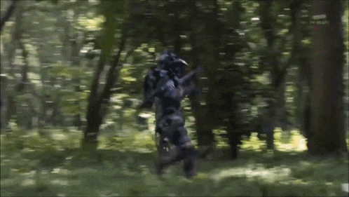 a blurred image of a person in a robotic suit in the woods