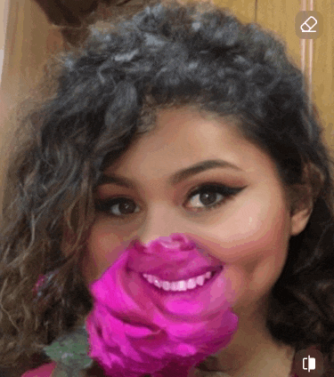 a woman with a pink rose on her face is smiling