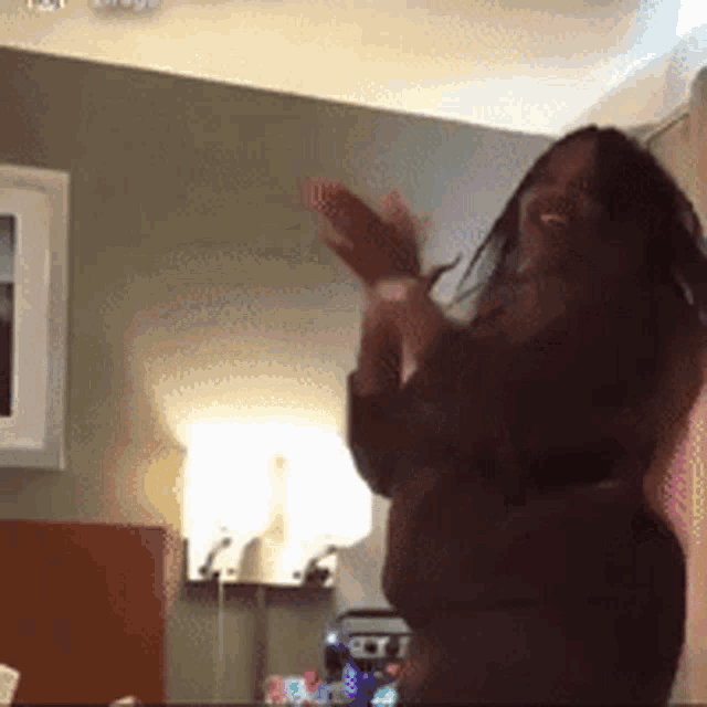 a woman is dancing in a room with her arms outstretched