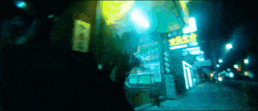 a blurry picture of a street at night with chinese signs
