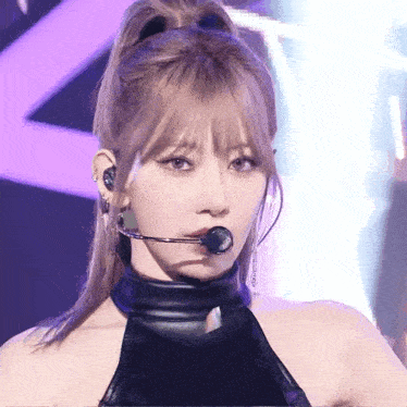 a woman wearing a microphone and a ponytail looks at the camera .