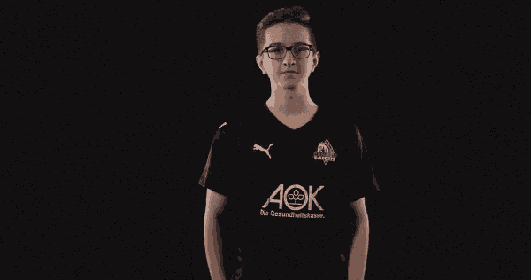 a man wearing a black aok shirt points up