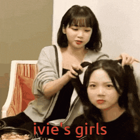 two girls are playing with each other 's hair and the caption ivie 's girls is visible
