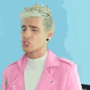 a young man wearing a pink jacket and a crown on his head .